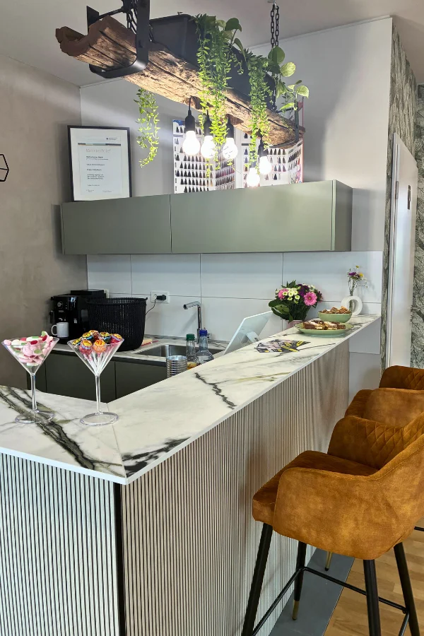 Friseur Wilhelmine Stetten – moderner Empfangsbereich mit Marmor-Theke und gemütlicher Einrichtung